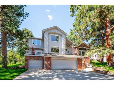 Charming two-story home with a well-maintained lawn, mature trees, and a two-car garage at 2397 Hearth Dr, Evergreen, CO 80439