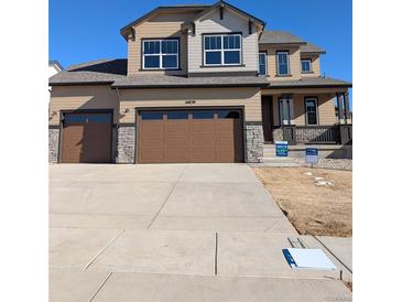 Two-story house with brown garage doors and a landscaped front yard at 16830 Mckay Dr, Mead, CO 80542