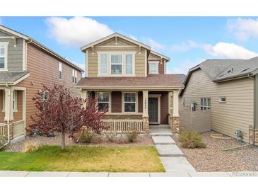 Charming two-story home featuring a cozy front porch and well-maintained landscaping at 15842 E Warner Dr, Denver, CO 80239
