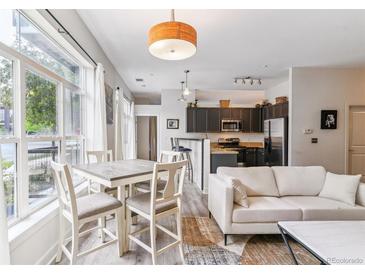 Bright living room with a dining table, modern furnishings, and large windows for natural light at 5677 S Park Pl # A102, Englewood, CO 80111