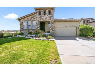 Charming stone accented two-story home with well-maintained lawn and attached two-car garage at 2373 S Joyce St, Denver, CO 80228