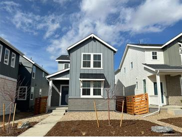 Charming two-story home featuring gray siding, white trim, and a welcoming front yard at 3325 N Coolidge Way, Aurora, CO 80019