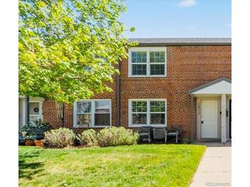Brick townhome featuring a well-maintained lawn, mature trees and updated windows at 2872 Jasmine St, Denver, CO 80207