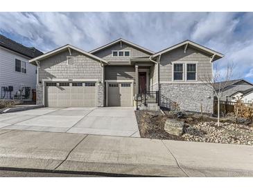 Two-story house with gray siding, stone accents, and a two-car garage at 2905 Morningbird Ln, Castle Rock, CO 80109