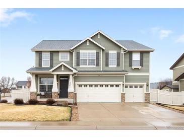 Beautiful two-story home with a three-car garage, attractive shutters, and manicured landscaping at 5861 Mt Shadows Blvd, Firestone, CO 80504