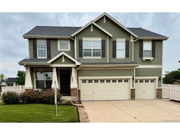 Inviting two-story home featuring a well-maintained lawn, attached two car garage, and lovely curb appeal at 5861 Mt Shadows Blvd, Firestone, CO 80504