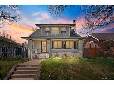 Charming two-story home featuring a well-manicured lawn, a brick walkway, and beautiful sunset views at 1065 Jackson St, Denver, CO 80206