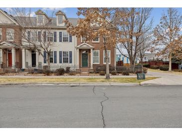 Charming townhome featuring brick and siding, a well-maintained lawn, and a welcoming fenced yard at 2449 Xanthia St, Denver, CO 80238