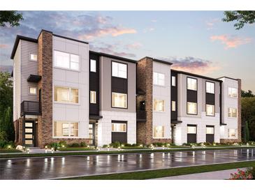 Modern three-story townhomes with brick and light-colored siding, showcasing a sleek design at 457 Interlocken Blvd # 102, Broomfield, CO 80021