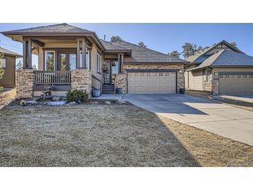 Charming single-Gathering home with a stone facade, covered porch, and well-manicured lawn at 23960 E Easter Pl, Aurora, CO 80016