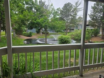Scenic pond view from the porch, featuring a fountain and lush greenery at 8600 E Alameda Ave # 105, Denver, CO 80247