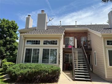 Inviting exterior showcasing a two-story condo with brick accents, large windows, and well-maintained landscaping at 13762 E Lehigh Ave # B, Aurora, CO 80014
