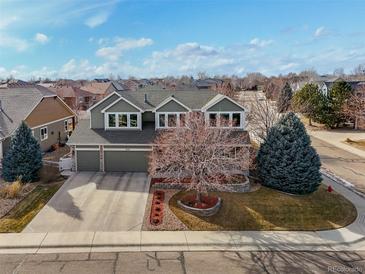 Charming two-story home featuring a three-car garage and landscaped front yard with a beautiful bare tree at 8775 Wild Horse Way, Frederick, CO 80504