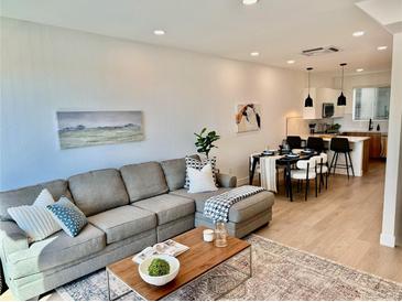 Open living room features stylish sectional sofa and flows into dining area at 5128 W 26Th Ave # 208, Denver, CO 80212