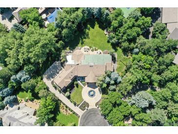 Expansive property featuring a grand residence surrounded by mature trees, manicured landscaping, and circular driveway with fountain at 4736 S Fillmore Ct, Cherry Hills Village, CO 80113