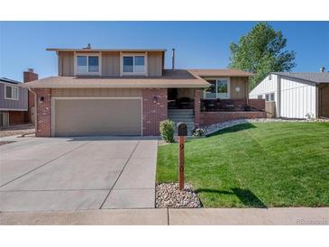 Charming two-story home features a well-maintained front yard and attached two-car garage at 9700 W 88Th Pl, Westminster, CO 80021