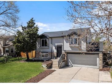 Charming two-story home featuring stone accents, a two-car garage, and a well-maintained front yard at 10895 W Bowles Pl, Littleton, CO 80127