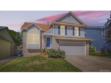 Lovely two-story home with blue shutters, brick accents, and a well-kept front lawn at sunset at 13069 Jackson Dr, Thornton, CO 80241