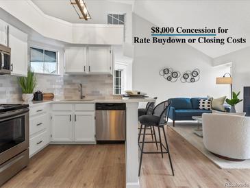 Well-lit kitchen showcasing stainless steel appliances and white cabinets at 11195 Alcott St # D, Westminster, CO 80234