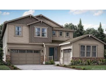 Charming two-story home with siding and stone accents, attached two and one car garages, and a landscaped yard at 14573 Hudson Way, Thornton, CO 80602