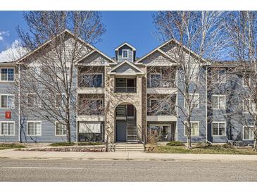 Beautiful condo complex with blue siding, well-maintained landscaping and a welcoming entrance at 4451 S Ammons St # 1-304, Littleton, CO 80123