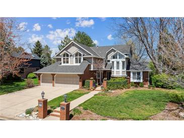 Charming two-story home boasts a manicured lawn, two-car garage, and brick accents at 3 Winged Foot Way, Littleton, CO 80123