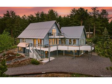 Stunning two-story home featuring a metal roof, wooden decks and a landscaped yard against a beautiful wooded setting at 31 Wild Tiger Ln, Boulder, CO 80302