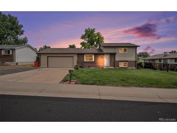 Charming single-Gathering home showcasing a manicured lawn and an attached two-car garage at 6413 W 76Th Ave, Arvada, CO 80003