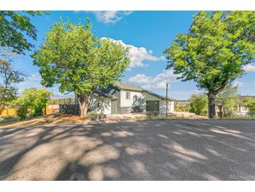 Charming home featuring a driveway, a well-kept lawn, and mature trees surrounding the property at 5385 W 51St Ave, Denver, CO 80212