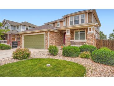 Charming two-story home with a stone facade, lush landscaping, and a well-maintained front yard at 19431 E Wyoming Ave, Aurora, CO 80017