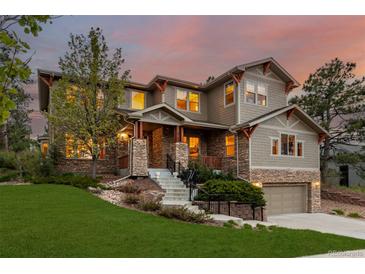Beautiful two-story home with stone accents, landscaped yard, and a two-car garage at sunset at 20166 E Shady Ridge Rd, Parker, CO 80134