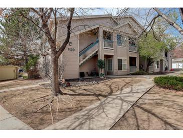 Inviting two-story condo building with blue stair accents, lush landscaping, and a well-maintained walkway at 1120 Opal St # 203, Broomfield, CO 80020