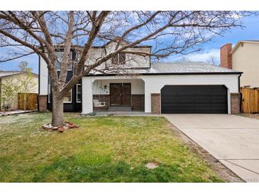 Charming two-story home featuring a two-car garage, front lawn, and inviting covered porch at 5716 S Lisbon Way, Centennial, CO 80015