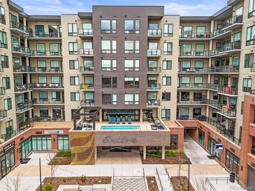 Exterior showcases a modern apartment building with private balconies and outdoor pool at 20 Wilcox St # 517, Castle Rock, CO 80104