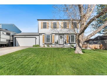 Charming two-story home featuring a well-manicured lawn and eye-catching wood shutters at 4733 S Vivian Ct, Morrison, CO 80465