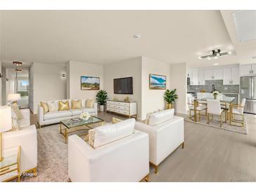Bright living room featuring white furniture, gold accents, and an open floor plan with view of the kitchen at 800 N Washington St # 1010, Denver, CO 80203