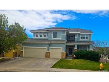 Charming two-story home with a three car garage, manicured lawn, and classic architectural details at 3590 S Malaya St, Aurora, CO 80013