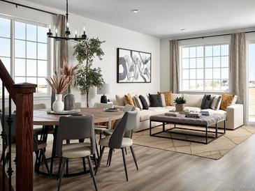 Bright living room featuring modern decor, a comfortable sofa, and large windows offering natural light at 24005 E Utah Pl, Aurora, CO 80018