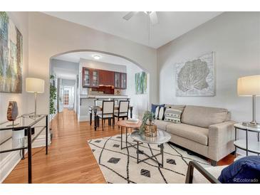 Bright living room features hardwood floors and an open layout leading to the kitchen and dining area at 132 W Bayaud Ave, Denver, CO 80223