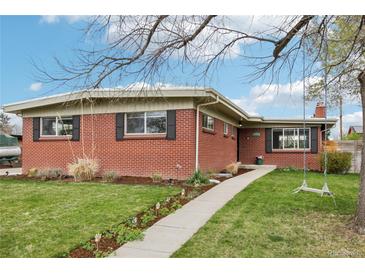 Charming brick home featuring a manicured lawn, quaint walkway, and mature landscaping at 6188 S Westview St, Littleton, CO 80120