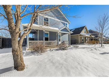Two-story house with gray siding, covered porch, and snow-covered yard at 2728 Renshaw St, Strasburg, CO 80136
