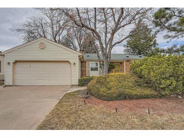 Charming single-story home featuring a brick facade, attached garage, and mature landscaping at 17332 E Prentice Cir, Centennial, CO 80015