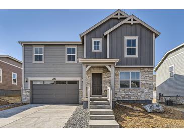 Charming two-story home featuring gray siding, stone accents, and a welcoming front porch at 22014 E 39Th Ave, Aurora, CO 80019