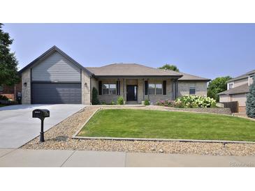Charming single-story home with a manicured lawn and a two-car garage at 1735 Crestone Dr, Longmont, CO 80504