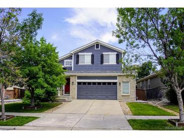 Charming two-story home with a well-manicured lawn, gray painted siding and a two-car garage at 2261 Alpine Dr, Erie, CO 80516