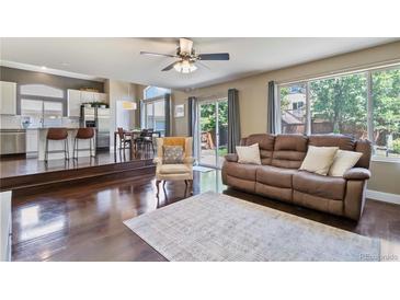 Open concept living area connects to kitchen and dining area; features hardwood floors, comfortable seating, and natural light at 2261 Alpine Dr, Erie, CO 80516