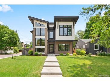 Modern two-story home with a combination of brick, siding, and large windows, complemented by a green lawn at 1500 S Elizabeth St, Denver, CO 80210