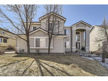 Charming two-story home featuring a manicured front yard, stucco exterior, and mature trees at 19406 E Maplewood Pl, Aurora, CO 80016