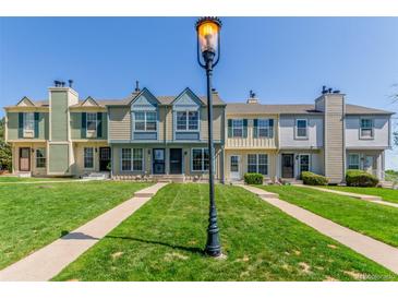 Charming townhomes with individual walkways and lush green lawns on a bright, sunny day at 1622 S Idalia Cir # E, Aurora, CO 80017