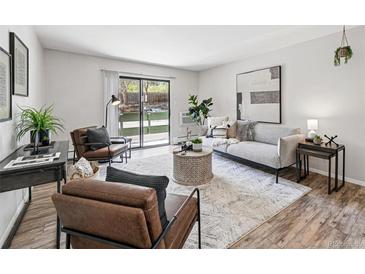 Bright living room featuring stylish furniture, area rug, and sliding glass doors to the outdoors at 7740 W 35Th Ave # 210, Wheat Ridge, CO 80033